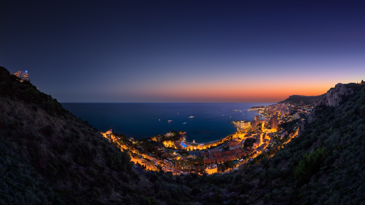 The lights of the city by the sea, the mountains at night