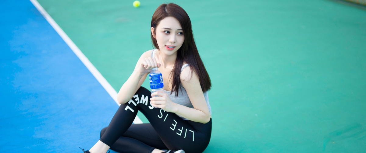 Cute long hair sitting on the tennis court