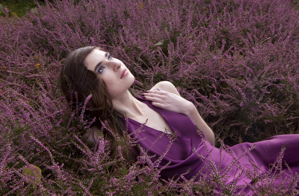 Beautiful girl with long brown hair and purple flowers