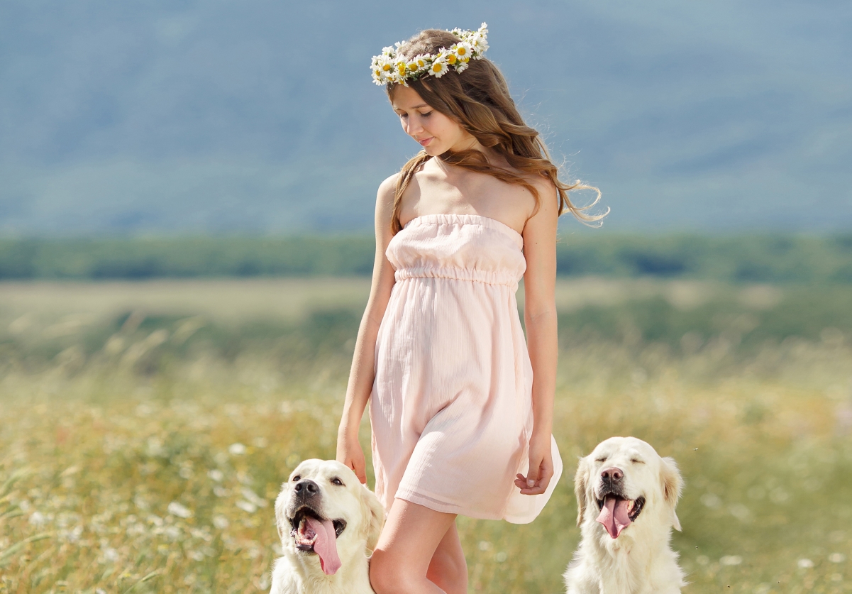 Brown-haired girl smiling with wreath dog