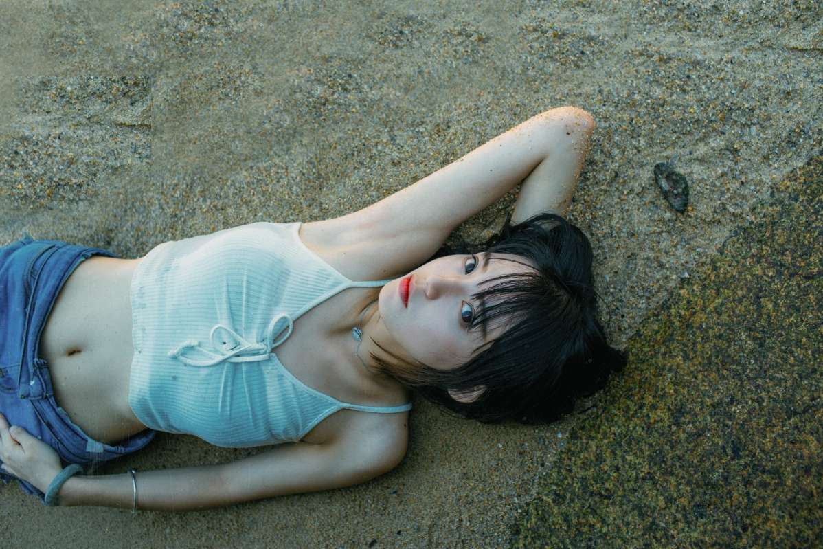 Beautiful woman lying on the beach by the sea 5K