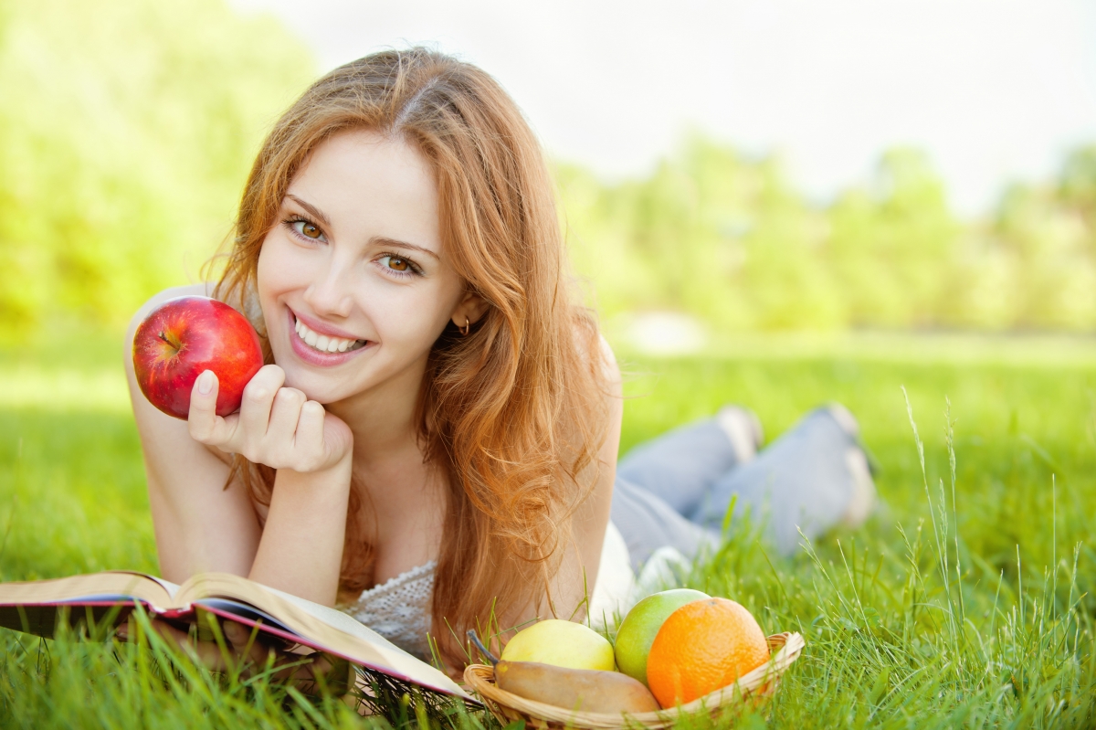 Girl reading book lying on the grass 4K