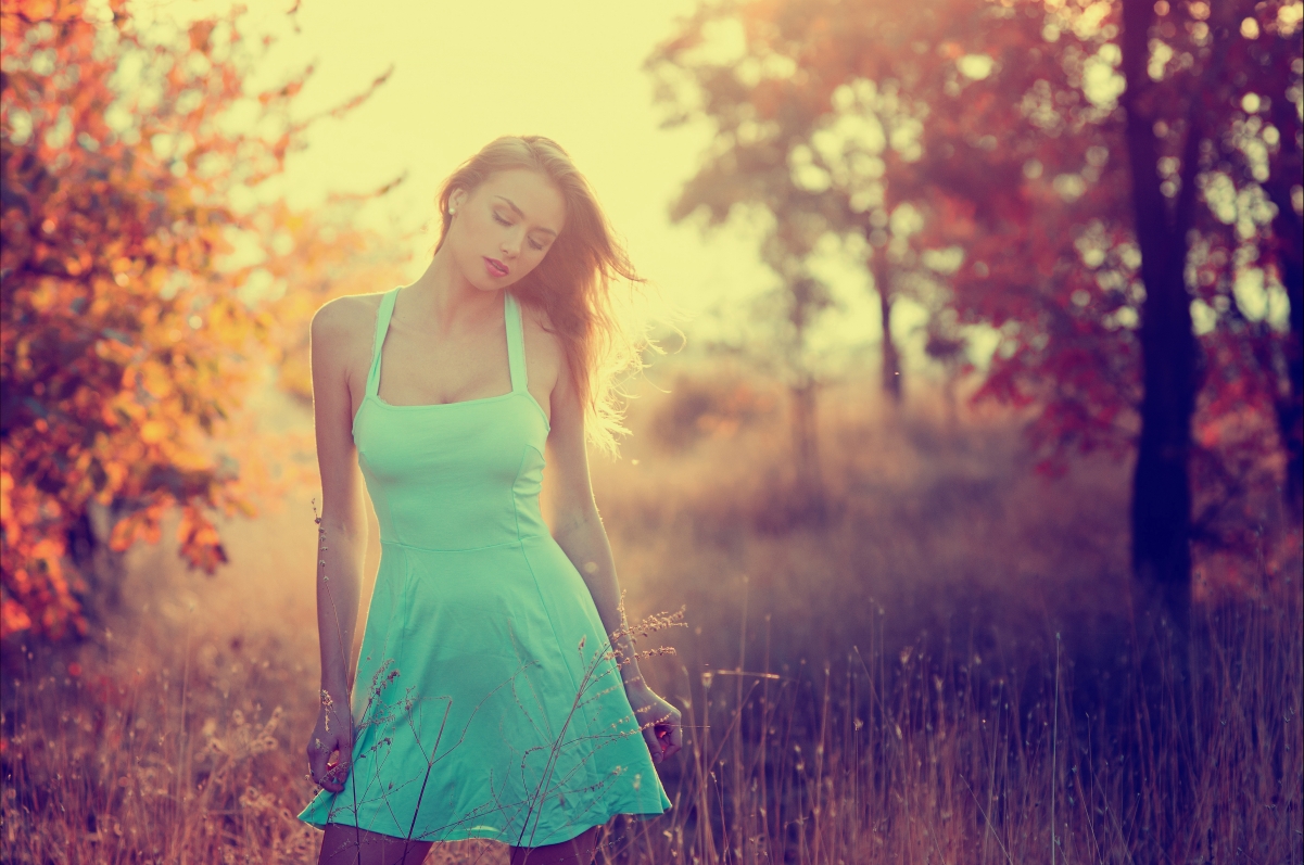 Girl in the woods with blond hair in a beautiful dress