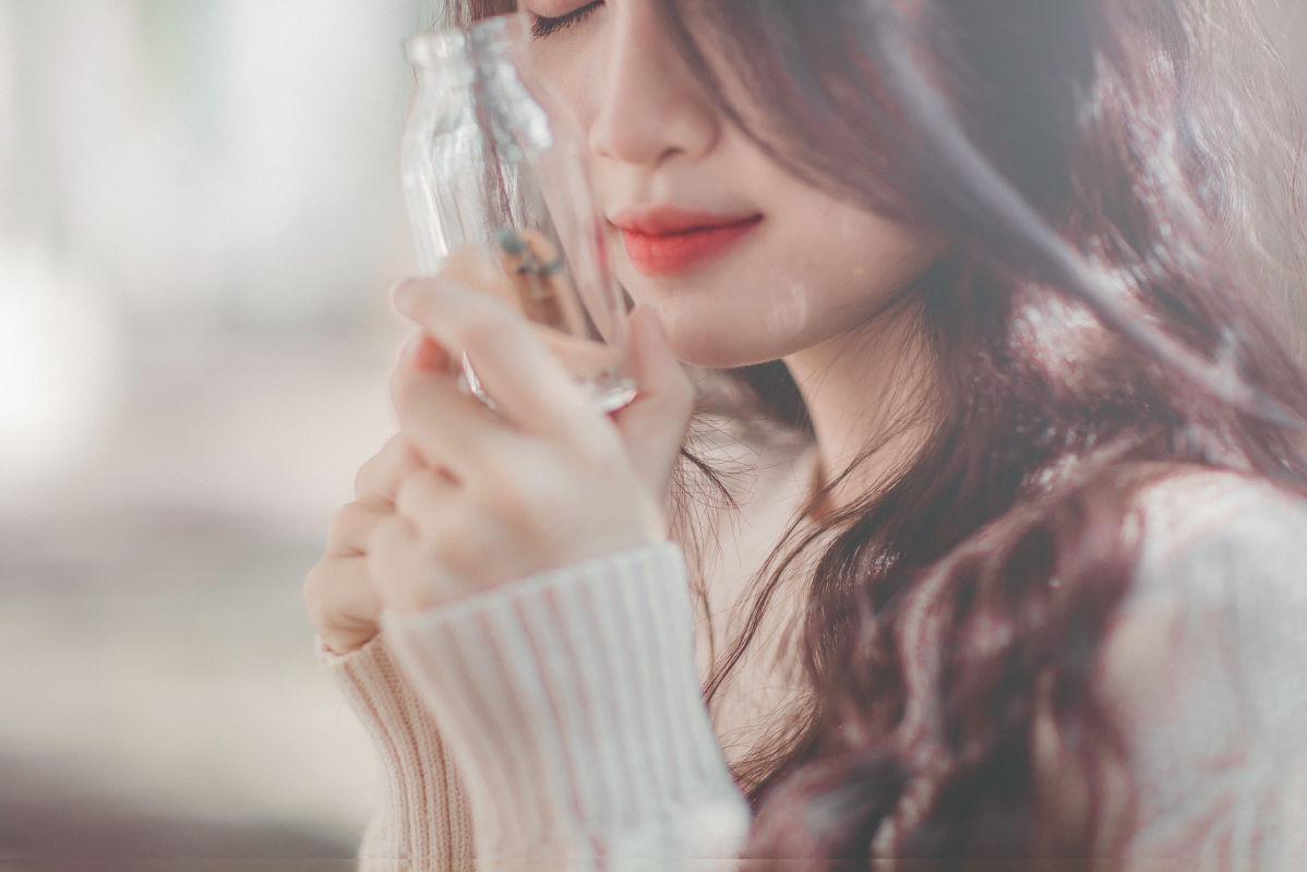 Beautiful girl holding a glass bottle 5k wallpaper