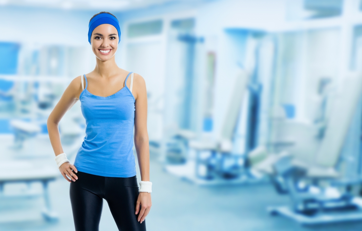 Happy young woman in gym