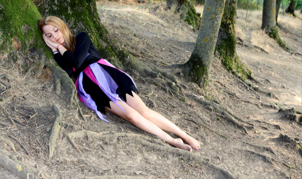 Blonde girl forest sleeping tree roots