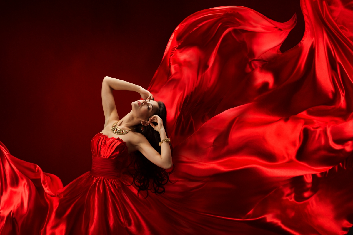 Beautiful woman with curly hair in red dress skirt