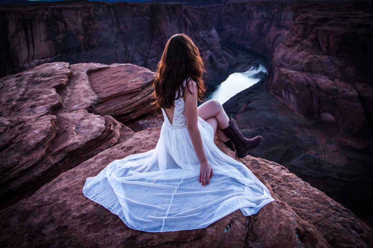 Beautiful woman in white dress in river canyon