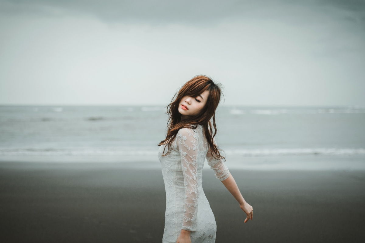 Beautiful lady in white dress on the beach