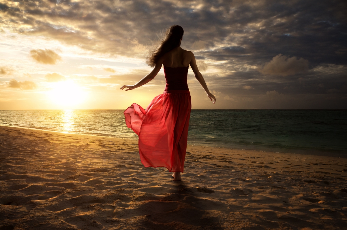 Beautiful girl in red skirt on the beach