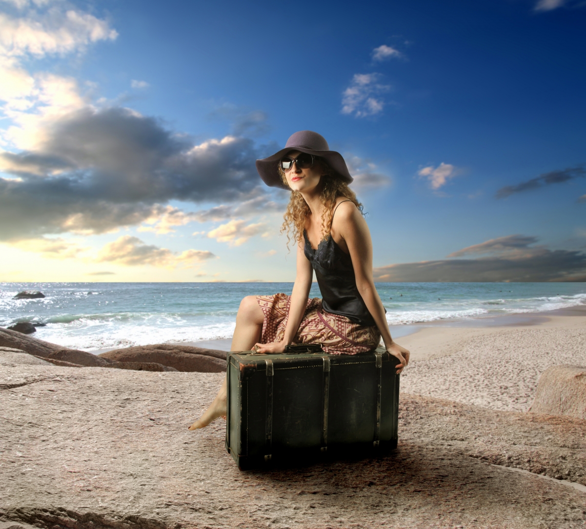Suitcase of beautiful foreign model by the sea