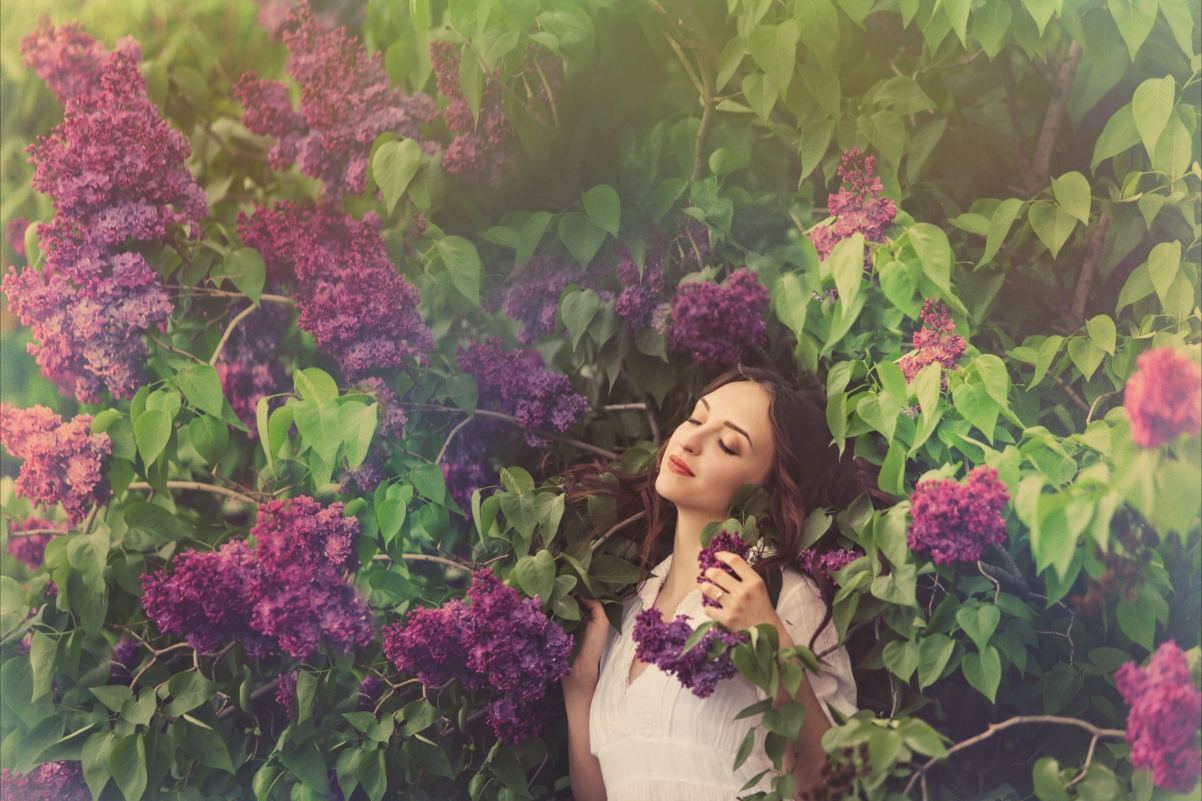 Beautiful woman with closed eyes in lilac flowers
