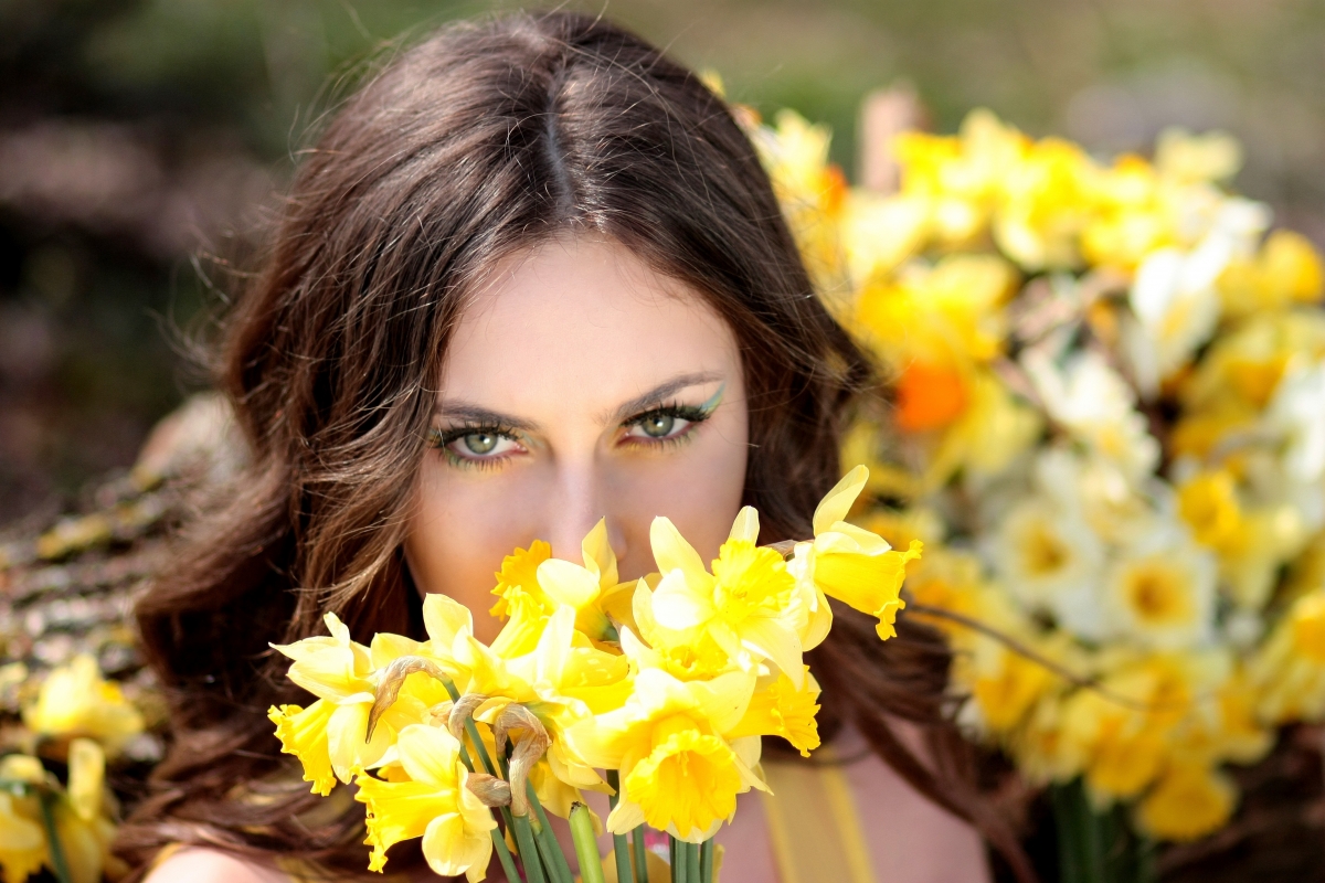 Beautiful woman with yellow daffodils in spring
