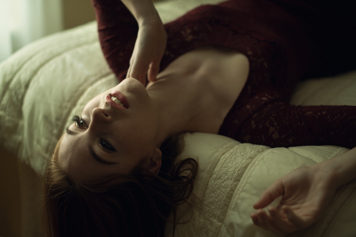 Beautiful foreign spotted woman poses by the bed