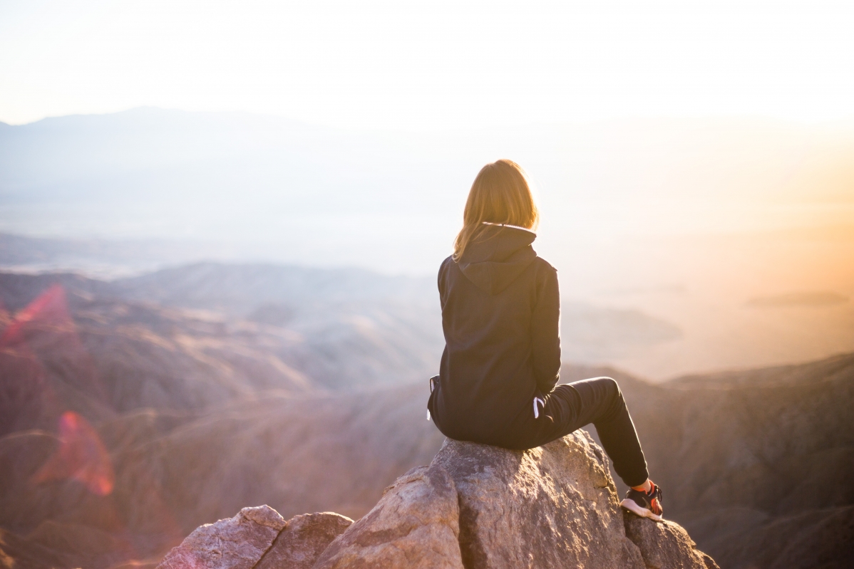Girl sitting on the top of the mountain 5K wallpaper