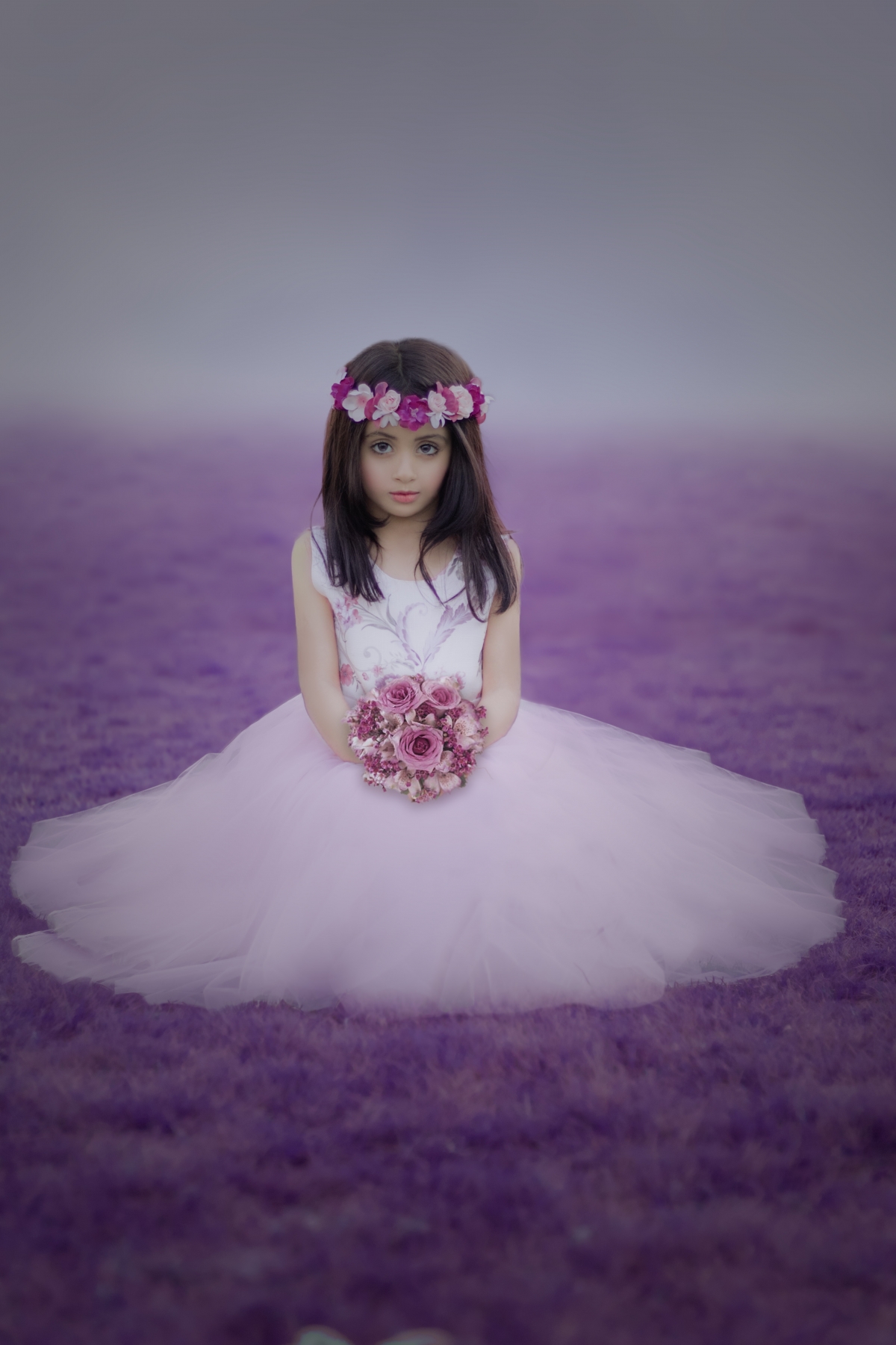 Little girl with flowers in white wedding dress