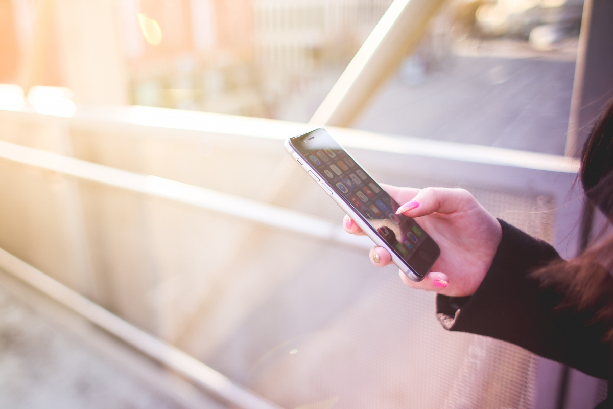 Young woman using iphone cell phone