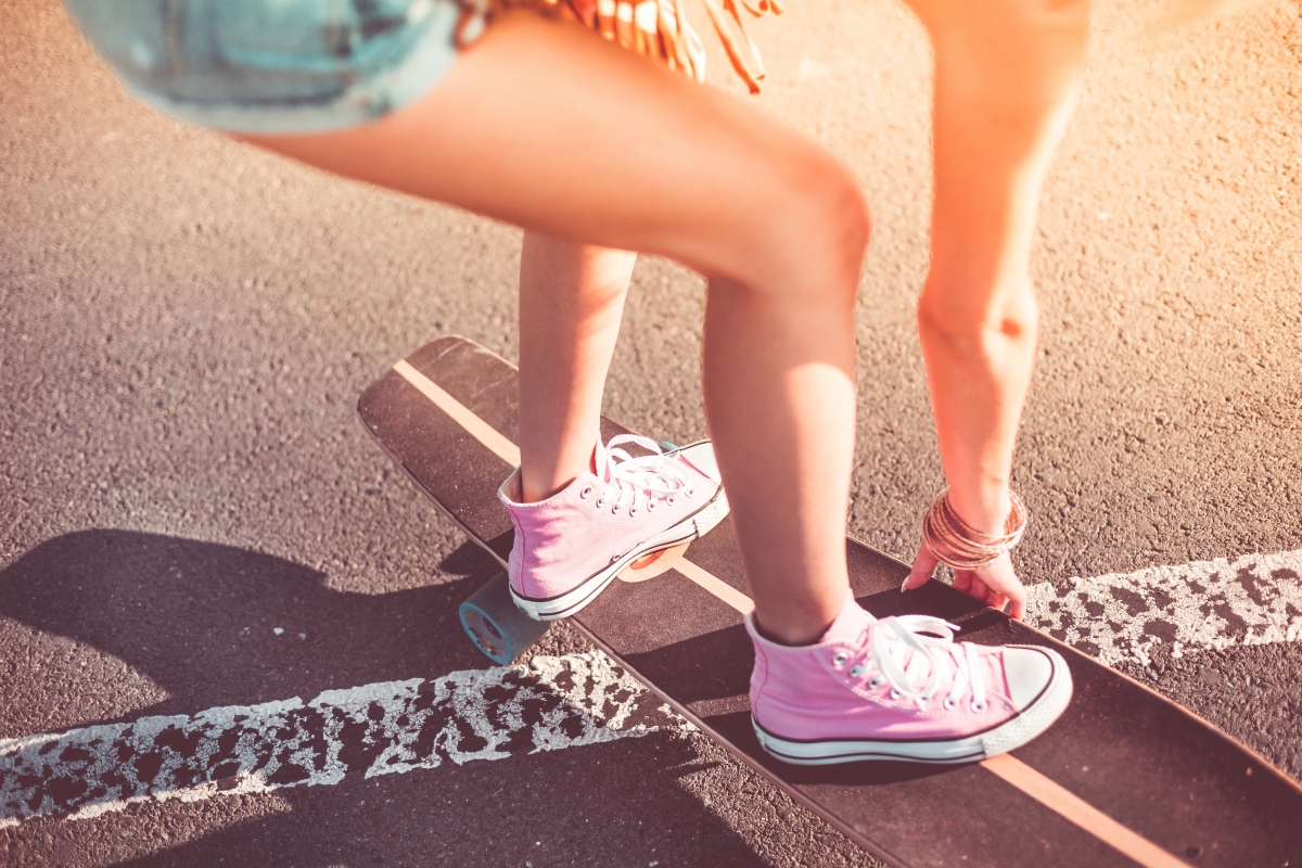 Young athletic girl skateboarding in pink