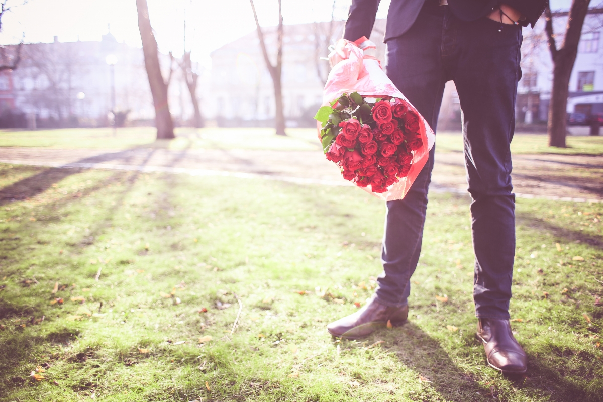 Man holding rose waiting for his lady