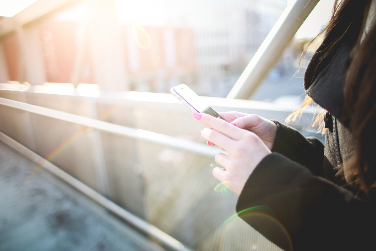 4k picture of a beautiful woman holding a mobile phone