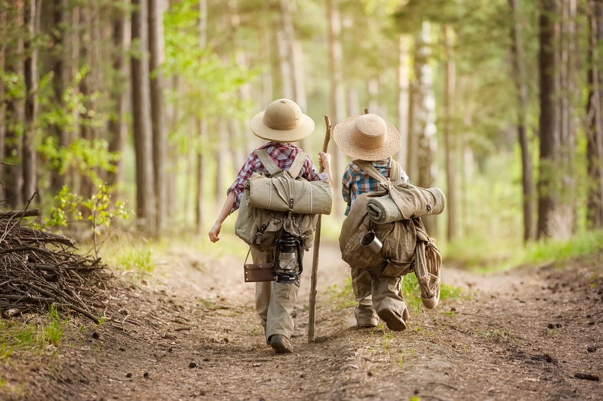 Two boys with backpacks trekking