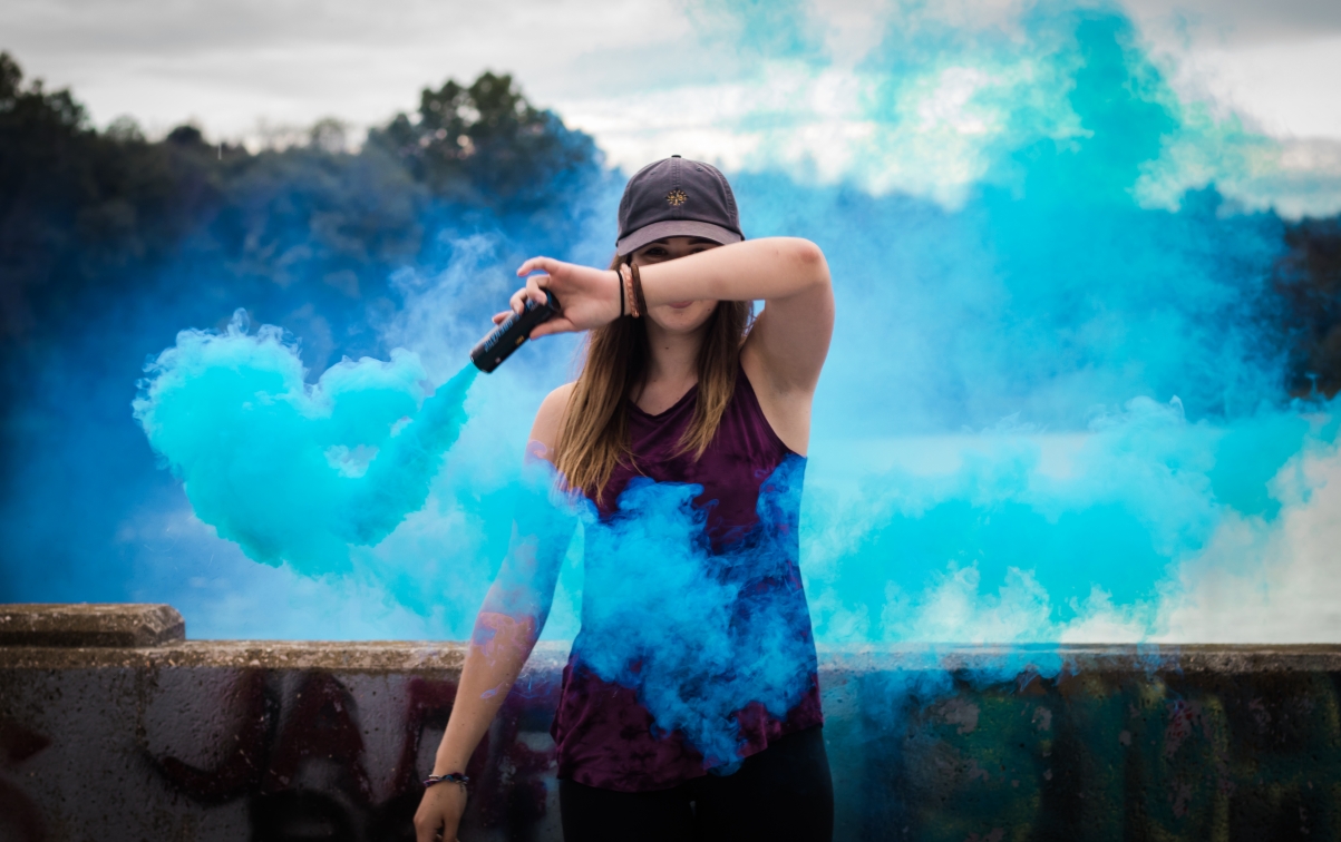 Beautiful fashion girl with blue smoke