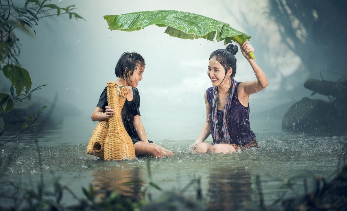 Young girl in rain pond in Cambodia