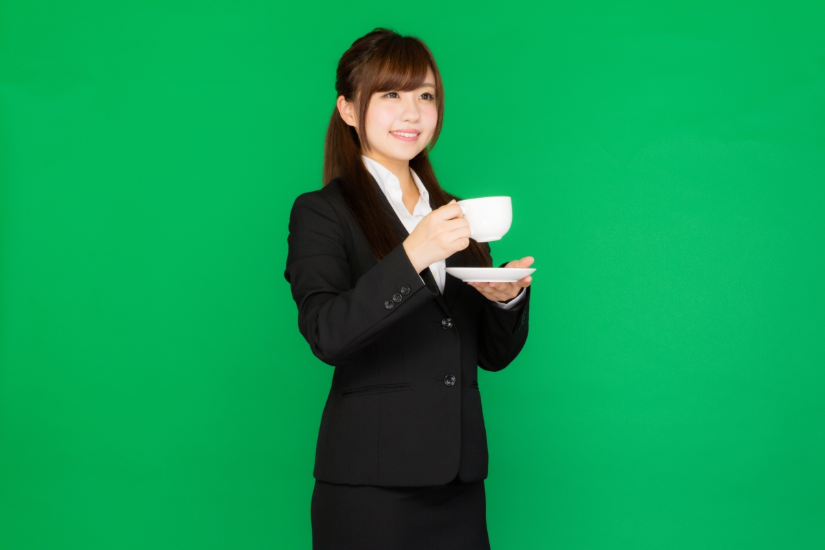 Drinking coffee, professional woman, green background