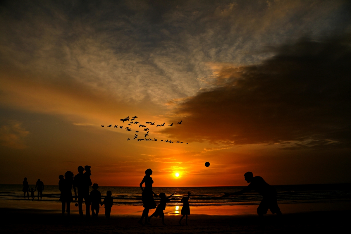 Family with children walking on the beach during vacation