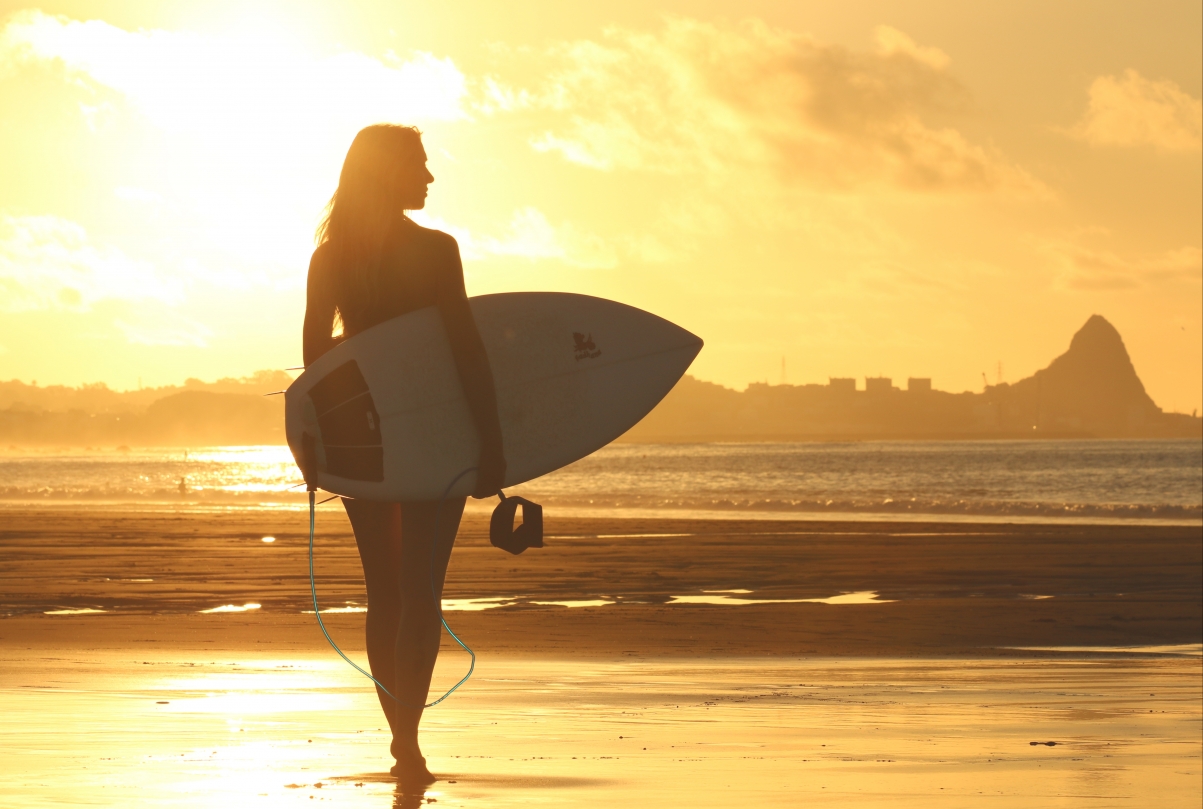 Beautiful woman holding a surfboard at the beach 5k picture