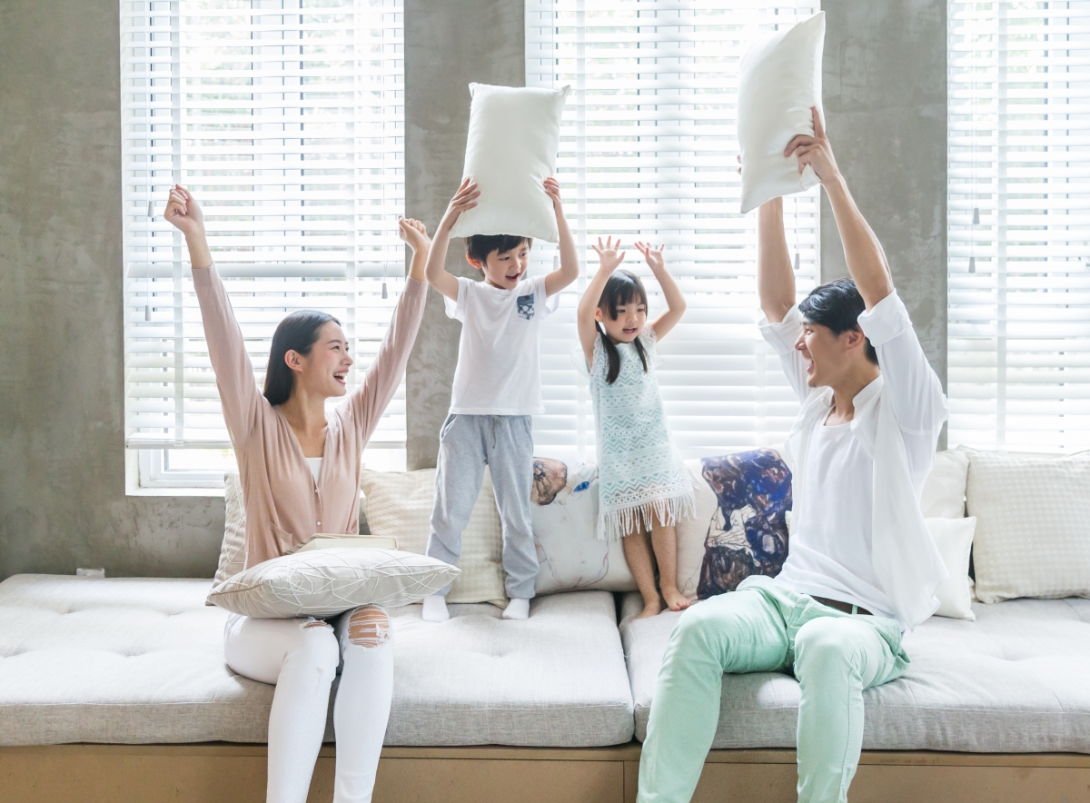 Parents and children frolicking on the sofa in the living room