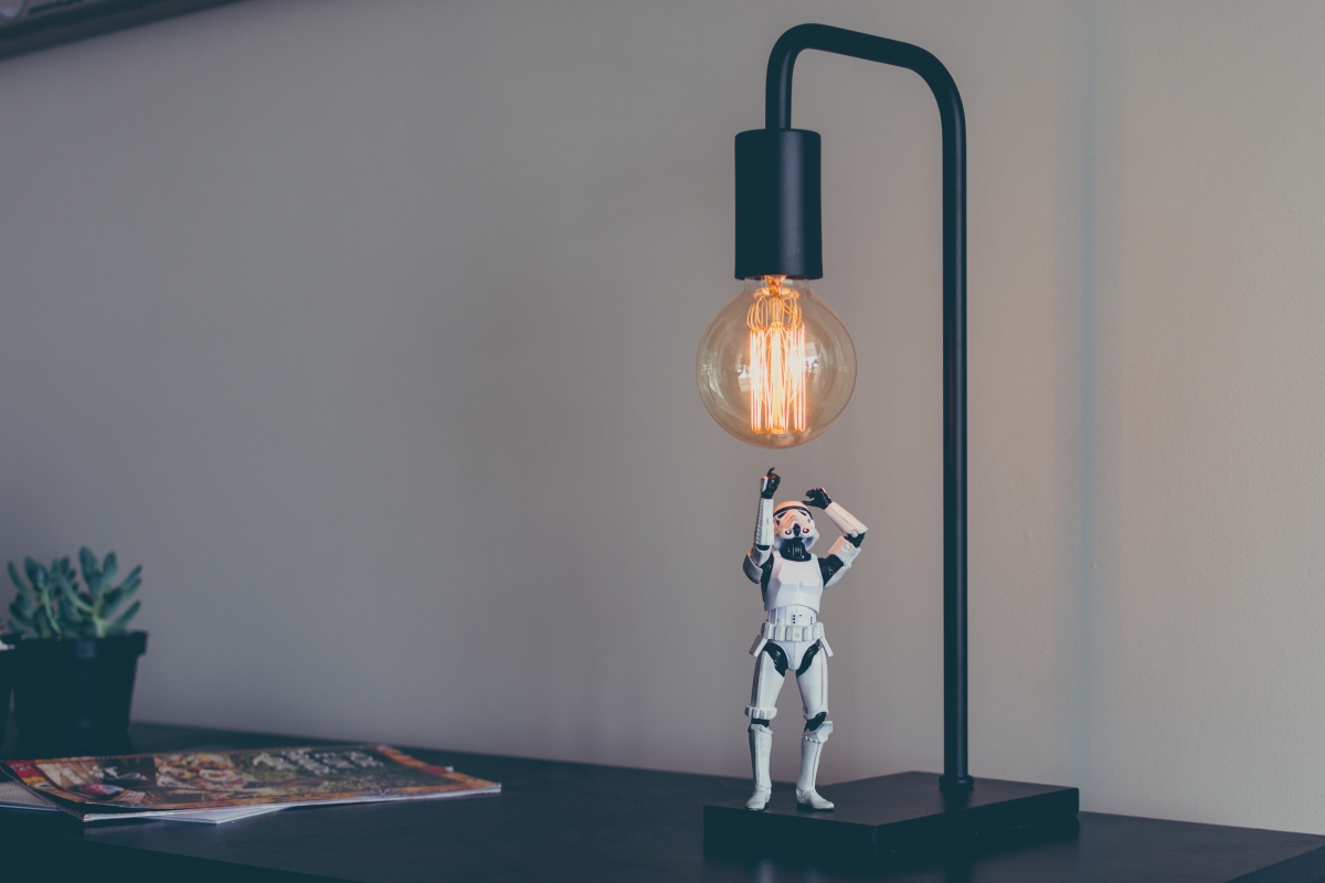 4k picture of a small robot under a desk lamp