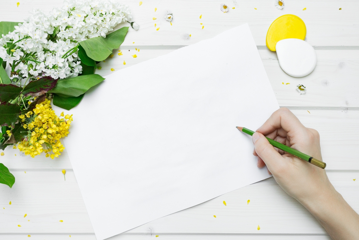 Hands, table, flowers, white paper,