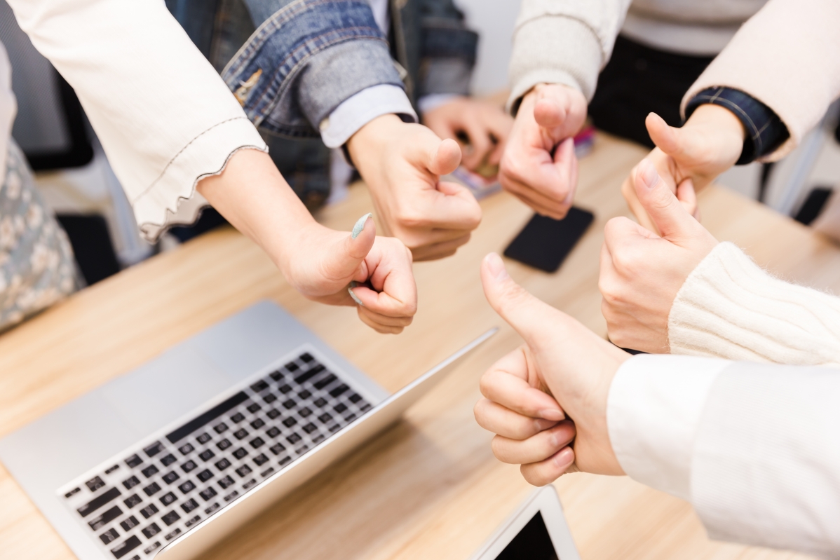 Close-up of business team holding thumbs up 5K