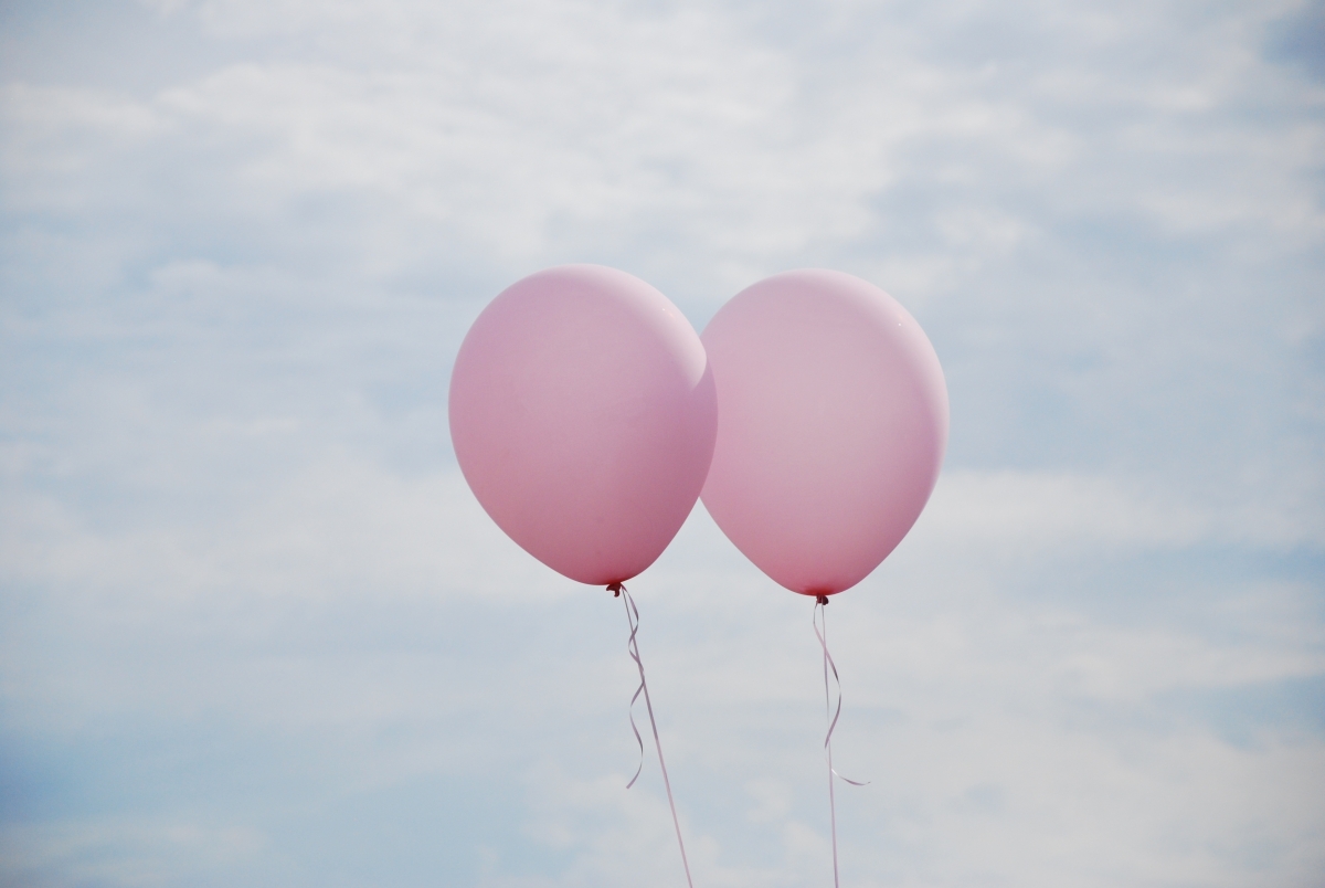 A pair of pink balloons in the sky